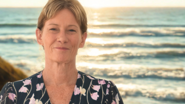 Carlene Prentice from Coastal Connect Counselling standing by the beach at sunset on the Gold Coast.